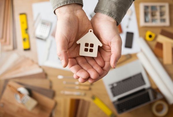 Hands holding small house charm